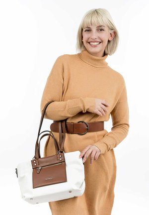 Sac à main blanc avec des accents marron, au design structuré et à double poignées. Le modèle porte un pull en tricot beige et une ceinture marron avec une boucle ronde.