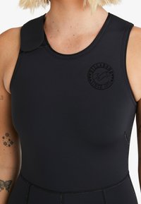 Traje de neopreno negro con cuello alto, cierre frontal con cremallera y parche texturizado en el hombro con un logo redondo. Material liso y elástico.