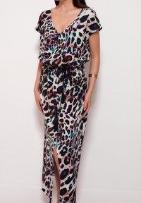 Robe à col en V et manches courtes en tissu léger, avec un imprimé léopard multicolore, une fente sur le côté et une ceinture assortie à nouer.