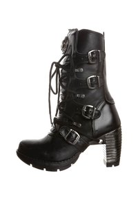 Sort læder knæhøj boot med snørebånd, fem justerbare spænder, tekstureret hæl og ribbet detalje. Udstyret med polerede metaldele.