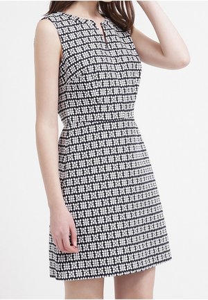 Robe sans manches noire et blanche avec un motif floral, encolure sans col, corsage ajusté et jupe évasée. Finition en tissu texturé.