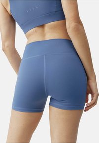 Blå treningsshorts laget av elastisk materiale, med en bred midjebånd, glatt tekstur og minimalistisk design med kontraststing.