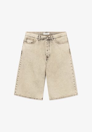 Shorts en denim beige stonewashed avec bouton avant, fermeture éclair, passants de ceinture et design à cinq poches, étiquetés "Wood Wood Type 16" à l'intérieur de la ceinture.