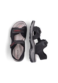 Sandales RIEKER noires avec deux bandes ajustables, design ouvert, dessus texturé noir, semelle intérieure rembourrée et semelle en caoutchouc légère. Accents rouges visibles.