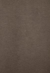 Brunt stickat tyg med en jämn, slät struktur. Inga distinkta mönster eller accenter syns. Lämpligt för kläder eller möbelklädsel.