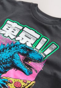 Black sweatshirt with a colorful graphic of a blue dinosaur holding a pepperoni pizza slice and bold white Japanese characters outlined in green.