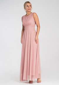 Maxikleid aus sanftem pinkfarbenem Stoff, mit einem figurbetonten Oberteil mit Falten, einer taillierten Taille und einem schwingenden Rock, der bis zum Boden reicht.