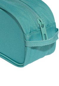 Funda cremoso color teal hecha de tela texturizada, con un diseño curvado, tirador de cremallera a juego y una pequeña correa lateral para un manejo fácil.