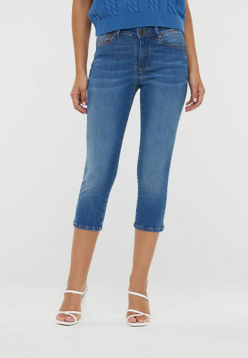 Jean court bleu foncé en denim, avec un design classique à cinq poches, un léger délavage sur les cuisses et une coupe droite.