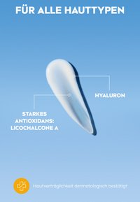 Ein weißer Cremetropfen auf einem blauen Hintergrund, der eine glatte Textur zeigt. Der Text hebt wichtige Inhaltsstoffe und dermatologische Verträglichkeit hervor.