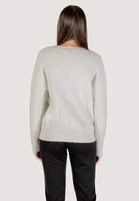 Maglione grigio chiaro a coste con una vestibilità ampia e maniche lunghe; presenta una finitura testurizzata sottile e un collo rotondo.