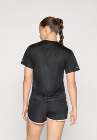 Black, short-sleeve athletic t-shirt with a smooth texture and subtle shine, paired with black shorts featuring white accents along the edges.