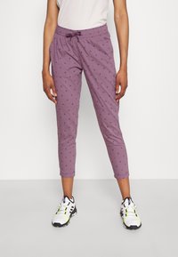 Light purple jogger pants with small, dark patterned accents, elastic waistband with drawstring, and cropped length. Paired with athletic shoes.