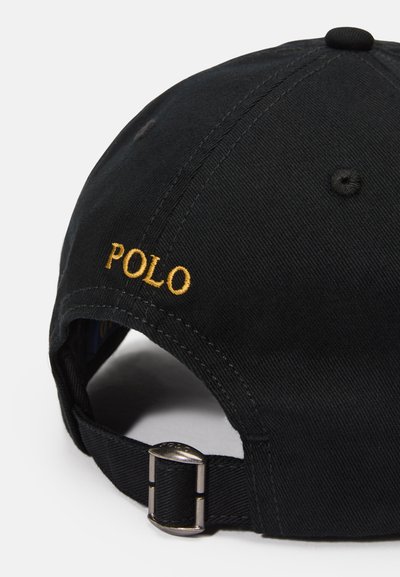 Boné de algodão preto com aba curva. Apresenta o logotipo "POLO" bordado em dourado. Fivela de metal ajustável na parte de trás para ajuste ao tamanho.