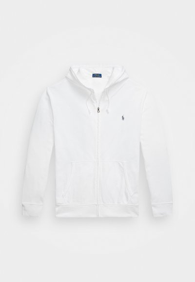 Haut zippé blanc en matière douce avec une poche kangourou, capuche à cordon de serrage et logo brodé sur la poitrine gauche.