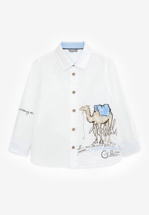 Hvid skjorte med knapper, med en kamelillustration og blå sadelgrafik på fronten, beige knapper samt broderet tekst på ærmet og brystet.