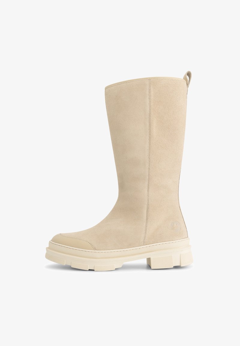 Beige suède enkellaarzen met een gladde afwerking, afgeronde neus en dikke rubberen zool met een gestructureerd profiel en een trekband aan de achterkant.