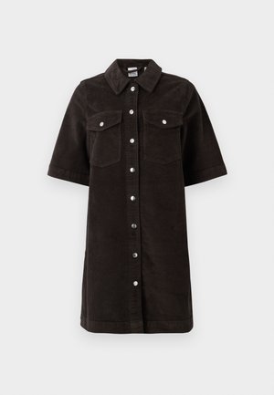 Μαύρο πουκαμίσα φόρεμα από χοντρό βελούδο με γιακά, κοντά μανίκια και δύο τσέπες στο στήθος. Διαθέτει ασημένια κουμπιά που κλείνουν με σνάπ στην μπροστινή πλευρά και είναι με ίσια γραμμή.