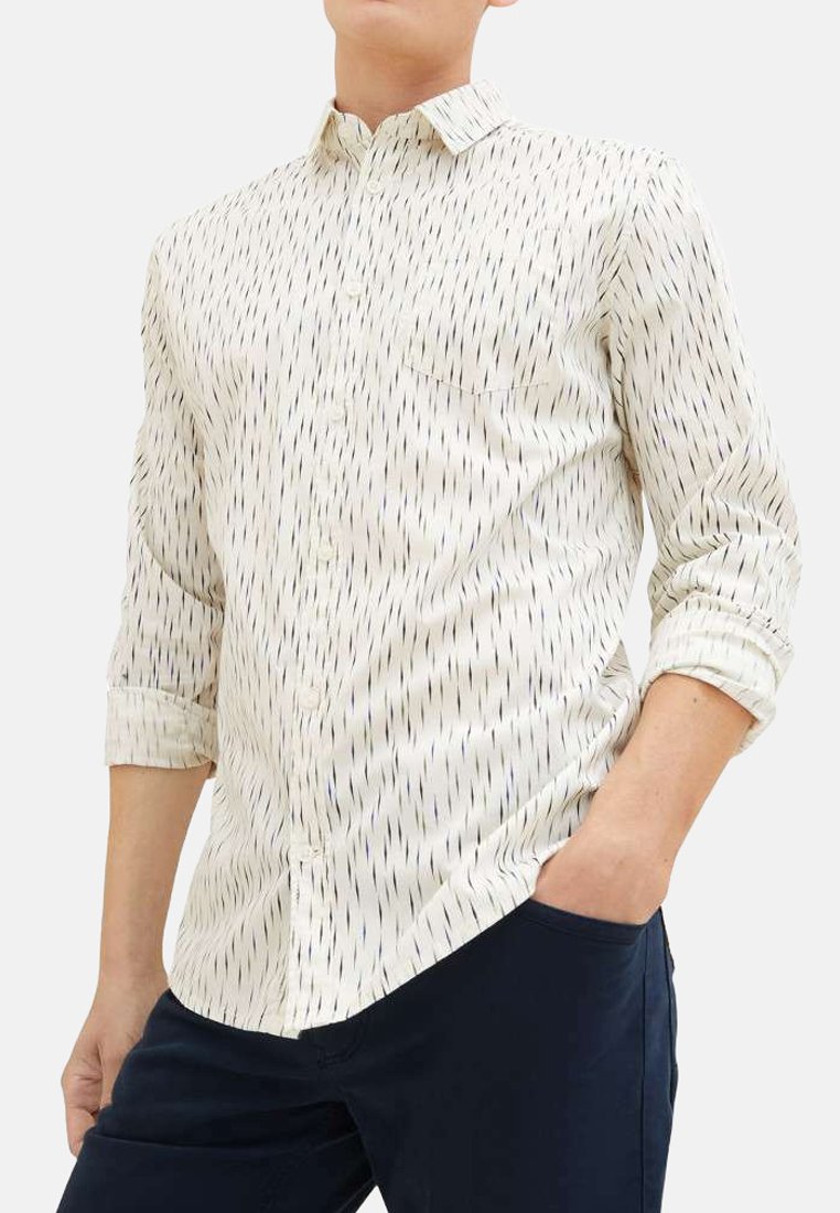Chemise blanche à boutons avec un motif de rayures verticales bleues et noires, manches longues retroussées aux poignets, et une poche poitrine. Texture de tissu lisse.