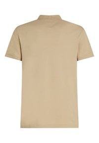 Polo beige à manches courtes montré de dos avec un col côtelé et des détails de couture simples.