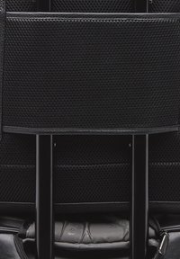 Zaino nero con texture in rete e dettagli in pelle, dotato di interno imbottito e cerniere trattate. Progettato per resistenza e funzionalità.