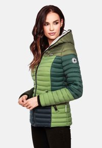 Padded green jacket with hood, featuring varying shades of green, ribbed texture, zippered pockets, and a logo patch on the arm.