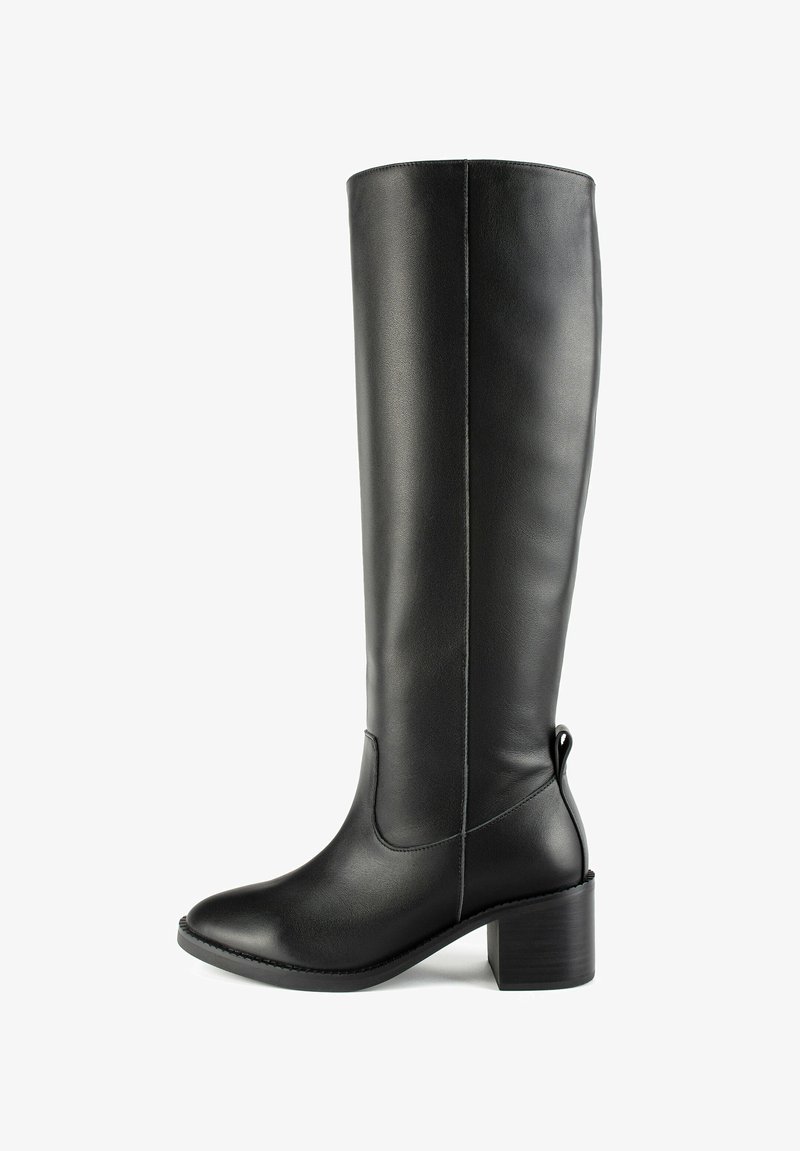 Botte en cuir noir montante avec un léger talon, texture lisse, bout pointu et coutures minimales. Elle comporte une poignée à l'arrière.