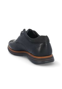 Zapato de cuero negro con acabado texturizado, detalles lisos y suela de cuero marrón. Presenta cordones y un cuello acolchado para mayor comodidad.
