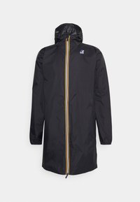 Chaqueta impermeable negra con capucha, cierre delantero con cremallera, detalle de rayas verticales en amarillo y blanco, y puños elásticos. Con logo en el pecho.