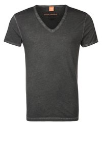 Tmavě šedé tričko s výstřihem do V vyrobené z měkké tkaniny, s krátkými rukávy a mírně opotřebovanou texturou kolem výstřihu a lemu.