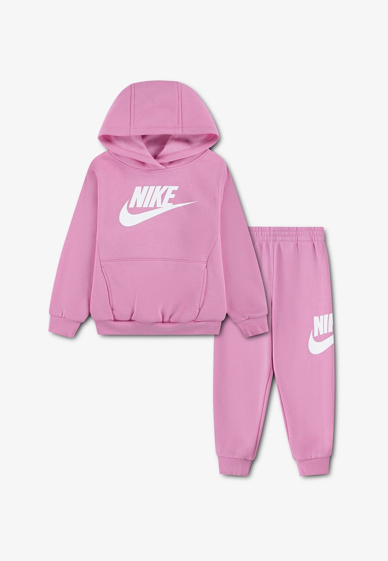 Розов суитшърт Nike и съответстващи панталони Jogger с бяло лого на Nike отпред и на лявото бедро, представени на светъл фон.