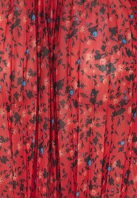 Rode bloemenpatroon stof met kleine blauwe en zwarte bloemen; lichtgewicht en doorschijnende textuur met verticale plooien overal.