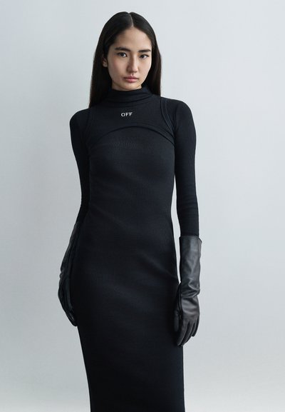 Robe col roulé côtelée noire à la silhouette ajustée, avec un petit logo "OFF". Associée à de longs gants en cuir noir élégants.