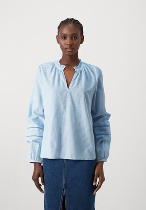 Blouse rayée bleu clair avec un col volanté, de longues manches bouffantes et des poignets élastiques. Le tissu a une texture lisse et un léger éclat.
