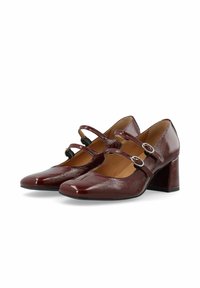 Zapatos de charol burdeos con punta cuadrada, dos correas ajustables y un tacón grueso. Textura suave con un ligero brillo.