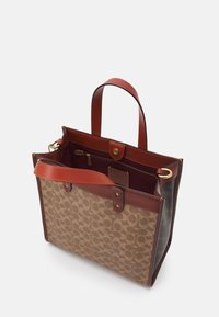 Brun lærred tote taske med læderdetaljer, prydet med et monogrammønster, top-håndtag, en guldtonet trykknaplukning og en indvendig lynlås lomme.