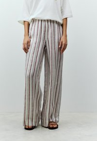 Pantaloni a gamba larga a righe in tessuto leggero. Presentano righe verticali bordeaux e crema, vita elastica e vestibilità rilassata.