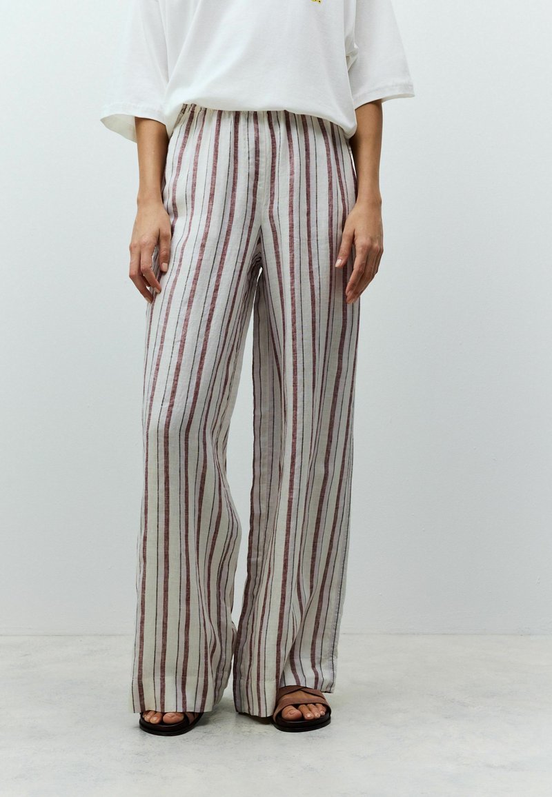 Pantaloni a gamba larga a righe in tessuto leggero. Presentano righe verticali bordeaux e crema, vita elastica e vestibilità rilassata.