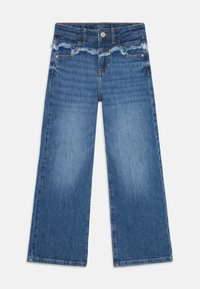 Jeans de perna larga em denim azul médio, com uma cintura desfiada, detalhes em costura laranja e bolsos de ambos os lados.