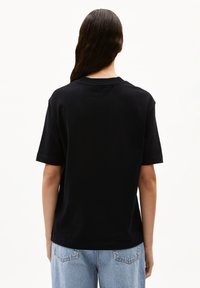 Zwarte katoenen t-shirt met korte mouwen, een relaxte pasvorm en een ronde hals. De achterkant laat een effen oppervlak zien zonder extra features of logo's.