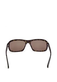 Lunettes de soleil rectangulaires à motif écaille de tortue avec des verres marron foncé et des branches fines noires, présentées de face sur un fond blanc.