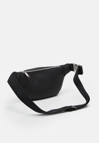 Crni fanny pack napravljen od teksturiranog materijala sa srebrnim patentnim zatvaračem, podesivim remenom, kompaktnim dizajnom i zakrivljenim, zaobljenim oblikom.