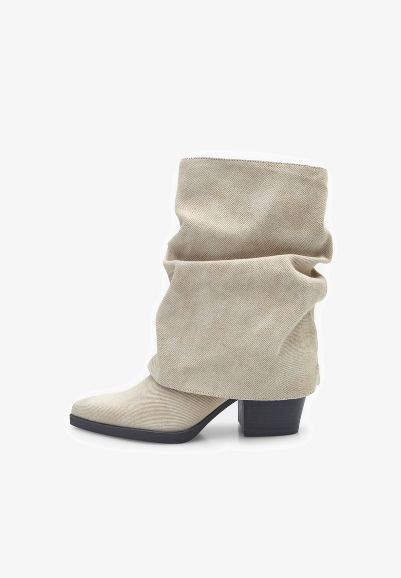 Beige slouch ankle boots, made of textured fabric, featuring a pointed toe and a chunky black heel.
