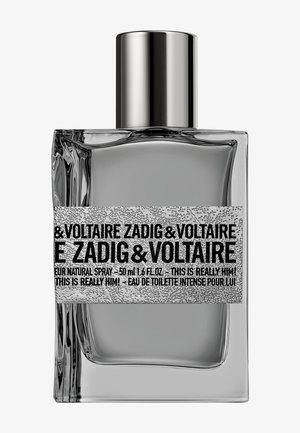 Eau de toilette en spray Zadig & Voltaire This Is Really Him! dans un flacon rectangulaire en verre transparent, avec un bouchon argenté et une étiquette texturée.