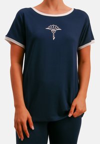 Marineblaue Kurzarm-T-Shirt mit weißem Besatz und einem kleinen weißen Grafikdesign in der Mitte. Hergestellt aus weichem, glattem Stoff.