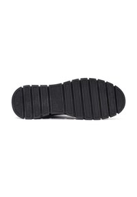Suela de zapato de goma negra con superficie texturizada, con múltiples estrías horizontales y puntera redondeada para mejorar la adherencia y el agarre.