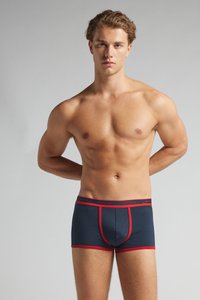 Námořnické boxerky s červenými akcenty. Měkká, elastická látka s přiléhavým střihem, která má tvarovaný pytlík a elastický pas s logem.