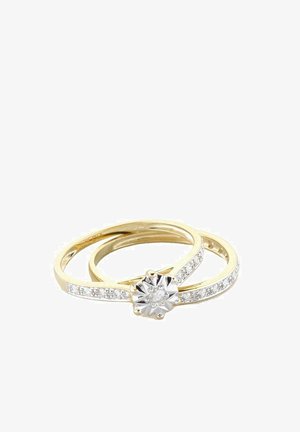 Set di anelli in oro e argento con una pietra centrale a taglio floreale, circondata da piccoli zirconi trasparenti lungo due bande.