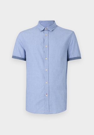 Camicia azzurro chiaro a maniche corte con colletto button-down, dotata di bottoni marrone chiaro e rifiniture contrastanti blu scuro sulle maniche.
