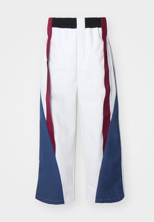Pantalones anchos blancos con paneles laterales en contraste en color burdeos y azul. Cintura elástica con detalles de cremallera en los costados.